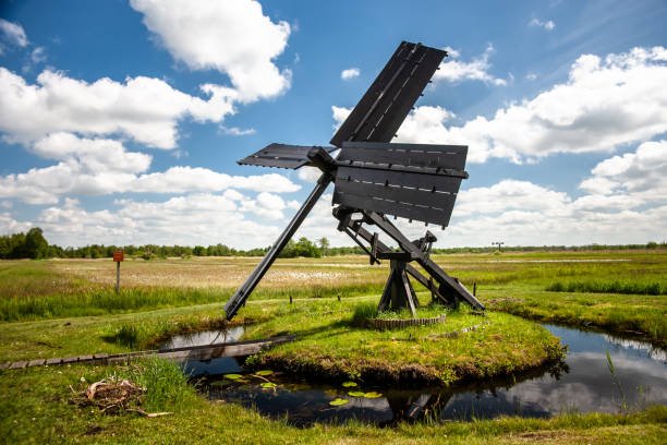 Typical dutch spinnekop mill in the national landscape the weerribben and wieden near Giethoorn and Kalenberg. It is suitable for the drainage of small polders and a typical traditional windmill in the Dutch landscape.